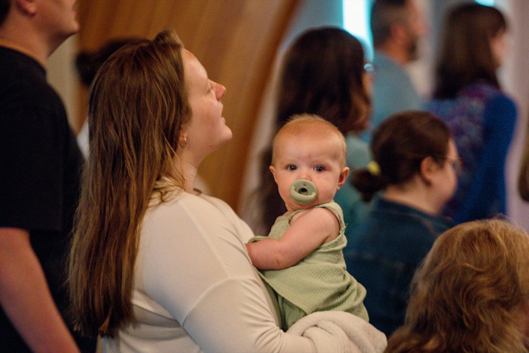 A parent holding a baby during a Calvary gathering